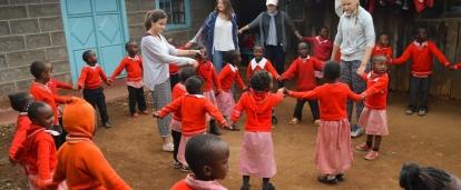 Volunteers play a game with the children outside during their volunteer work with children for teenagers in Kenya Projects Abroad volunteers assist with childcare volunteering for teenagers in Kenya as they play educational games with the children in the school yard